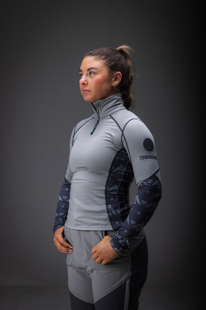 A woman modeling a gray base layer with a tribal eagle print, consisting of a long-sleeve top and leggings.