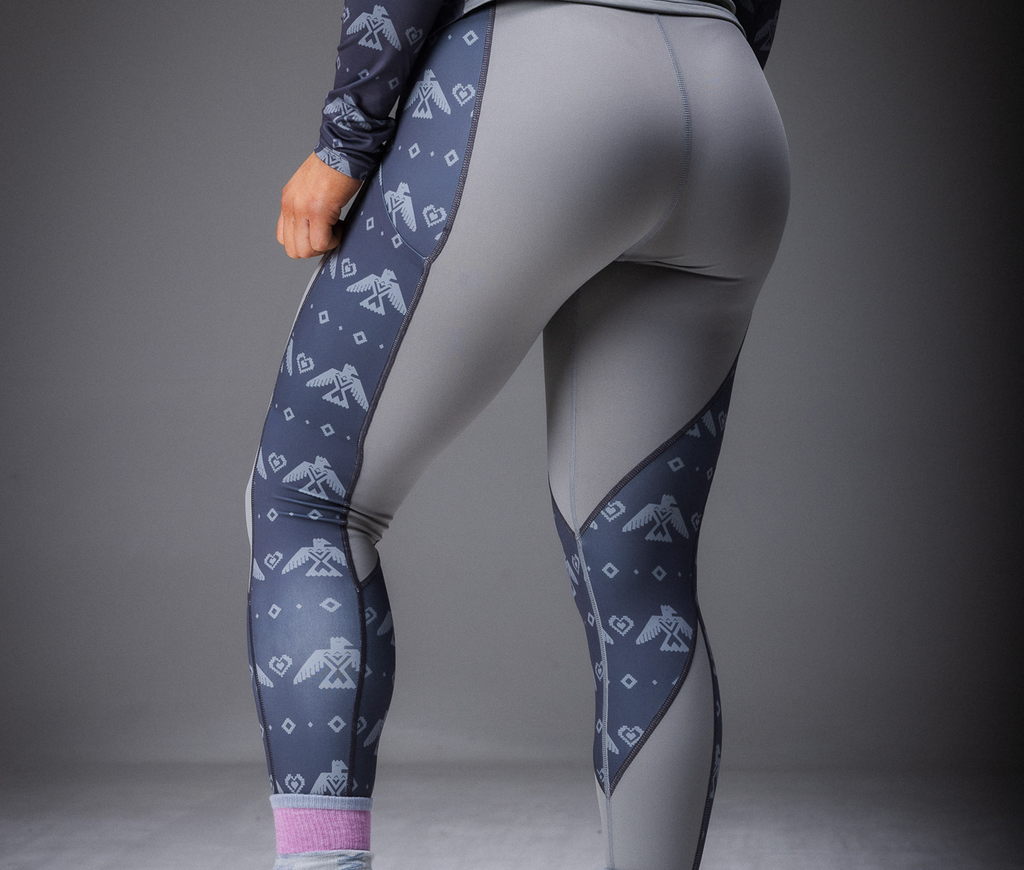 A woman modeling a gray base layer with a tribal eagle print, consisting of a long-sleeve top and leggings.